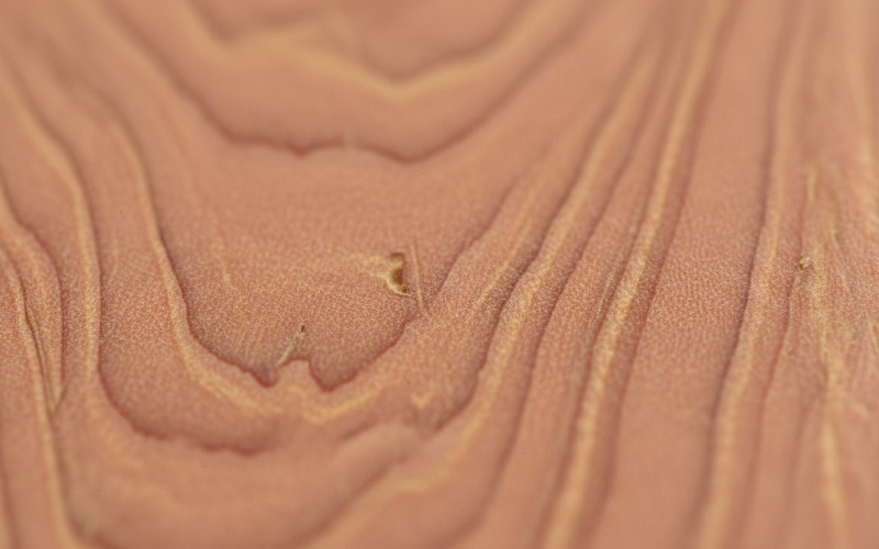 Close up inspection of Okoume wood grain pinkish texture for identification