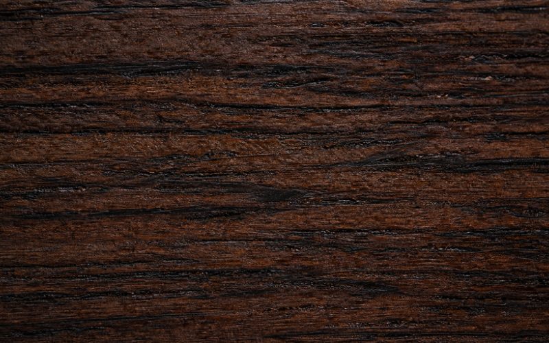 Macro shot of African Wenge wood showing dark black grain and chocolate brown fiber structure