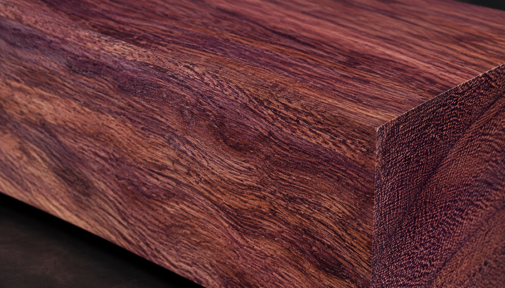 Close-up of kossipo timber showing interlocked grain and purple-brown hues